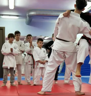 Maestro de Jiu Jitsu de Hansu demostrando una técnica con un alumno mientras el grupo observa
