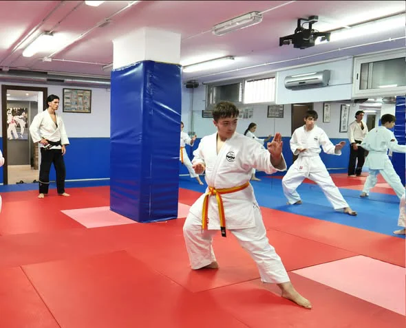 Alumnos de Jiu Jitsu de Hansu practicando una posición baja en el tatami